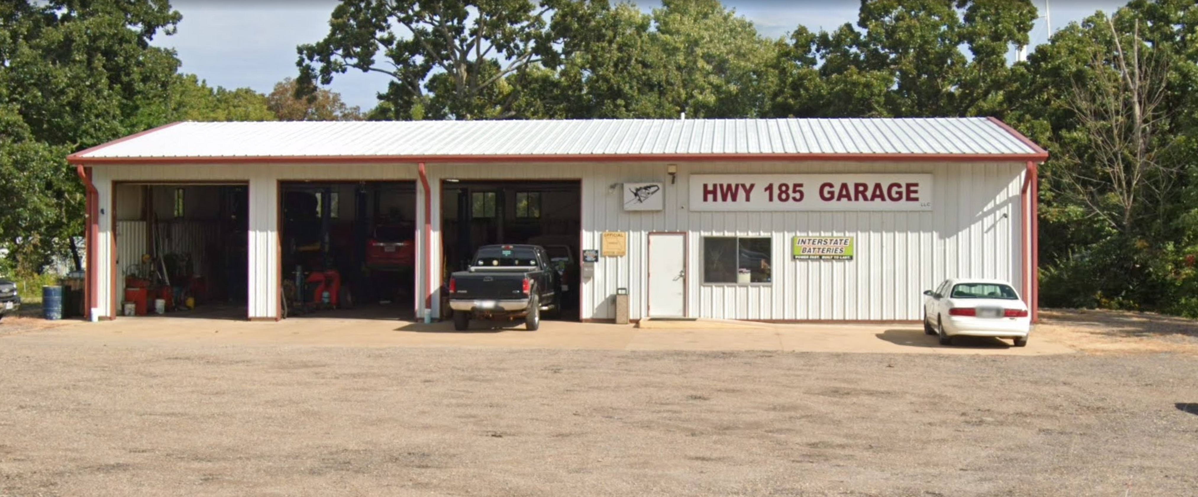 HWY 185 Garage in Sullivan, with its red and white sign and three open service bays